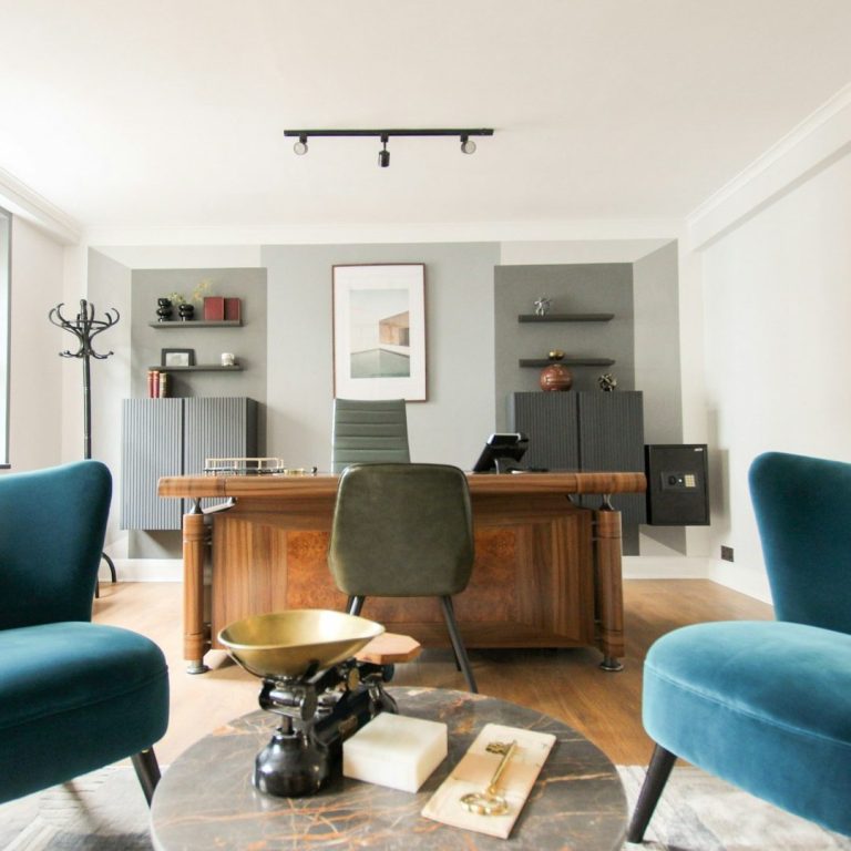 Oficina moderna con sillas turquesas, escritorio de madera y estanterías en las paredes.