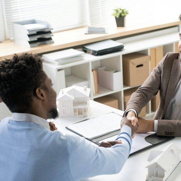 Hombres de negocios estrechándose la mano durante una reunión en una oficina moderna.
